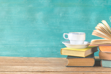 Bücher und eine Kaffeetasse auf einem Tisch