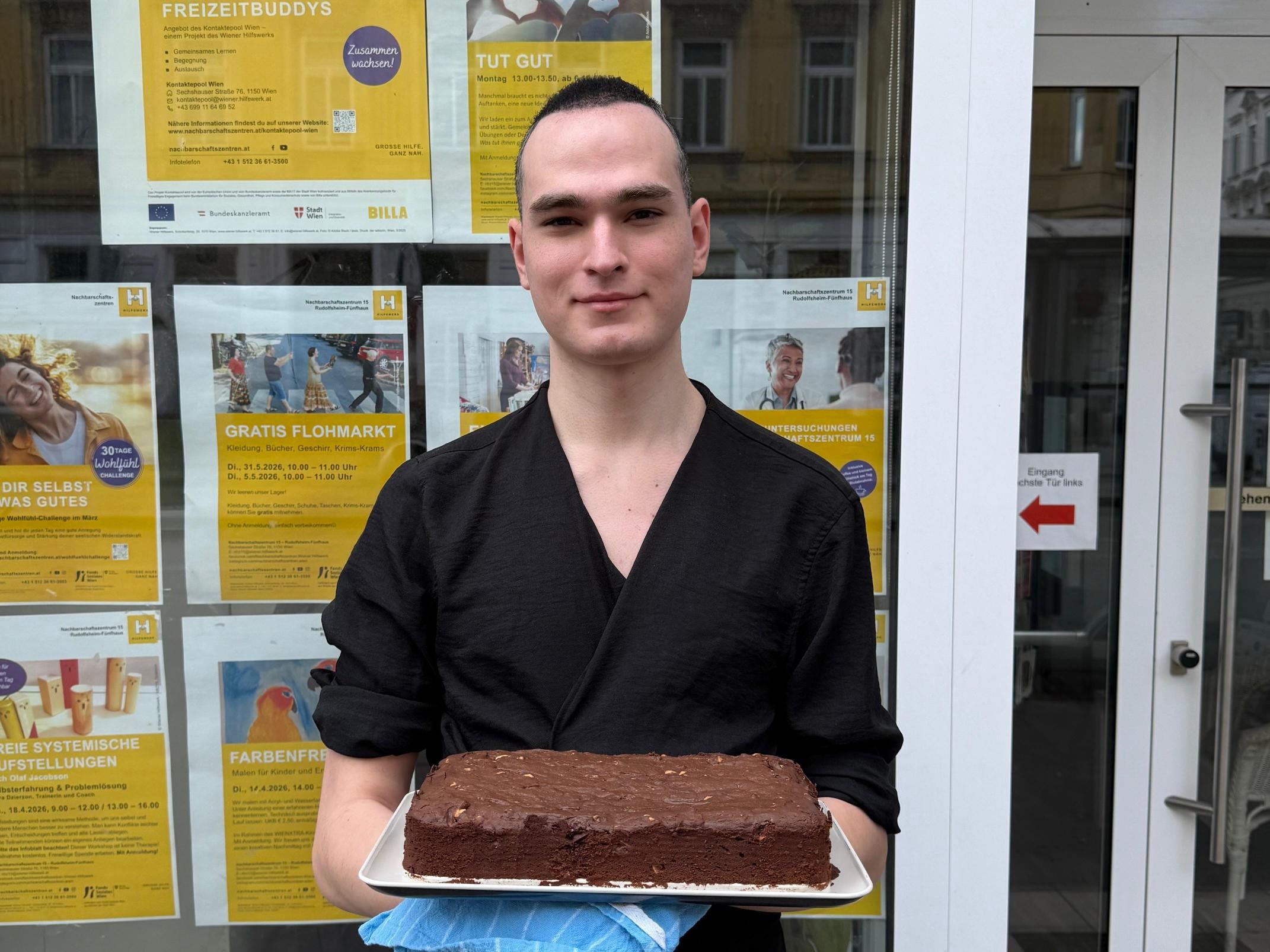 John präsentiert selbstgebackene Brownies vor dem Sprachencafé