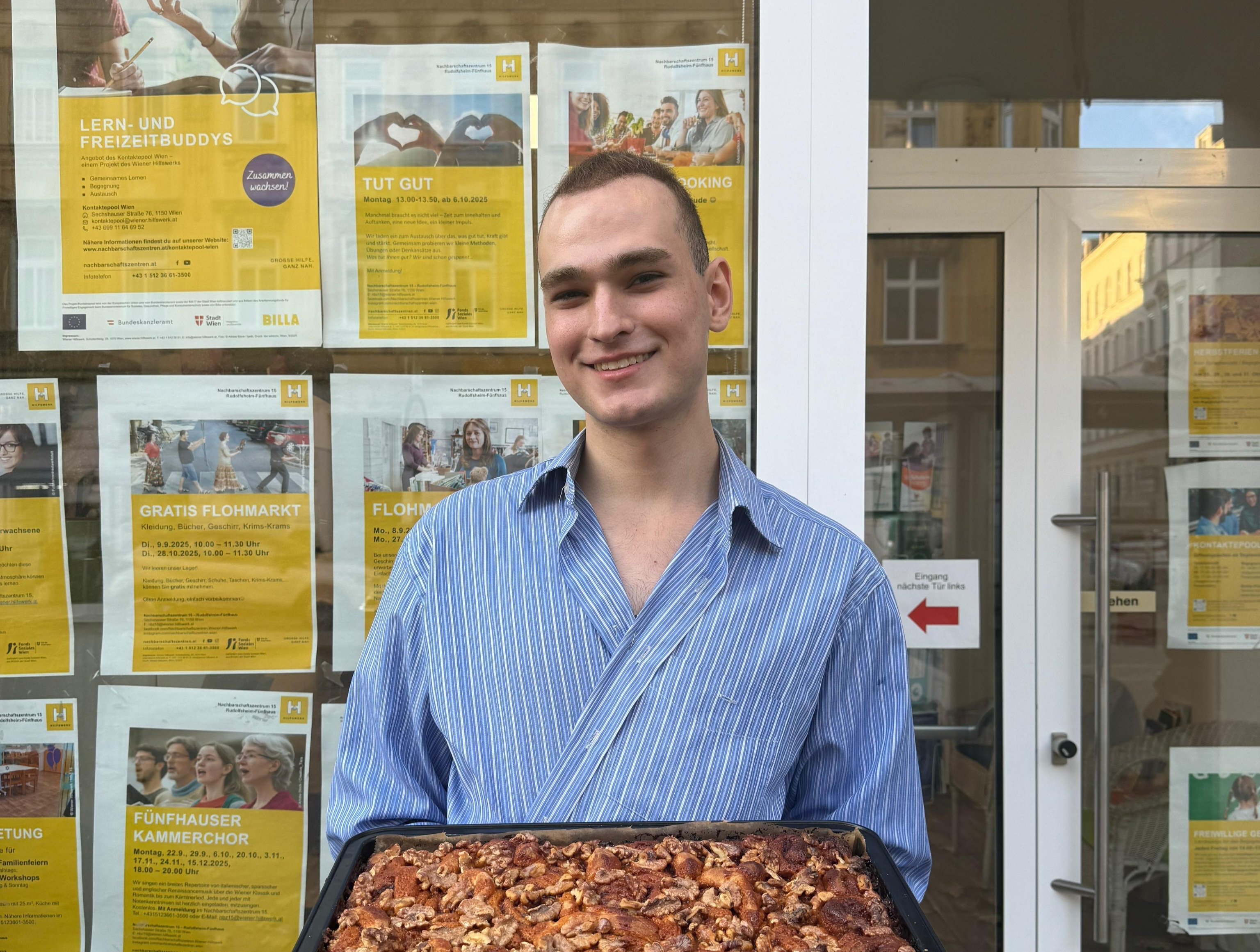 John präsentiert selbstgebackene Zimtschnecken vor dem Sprachencafé