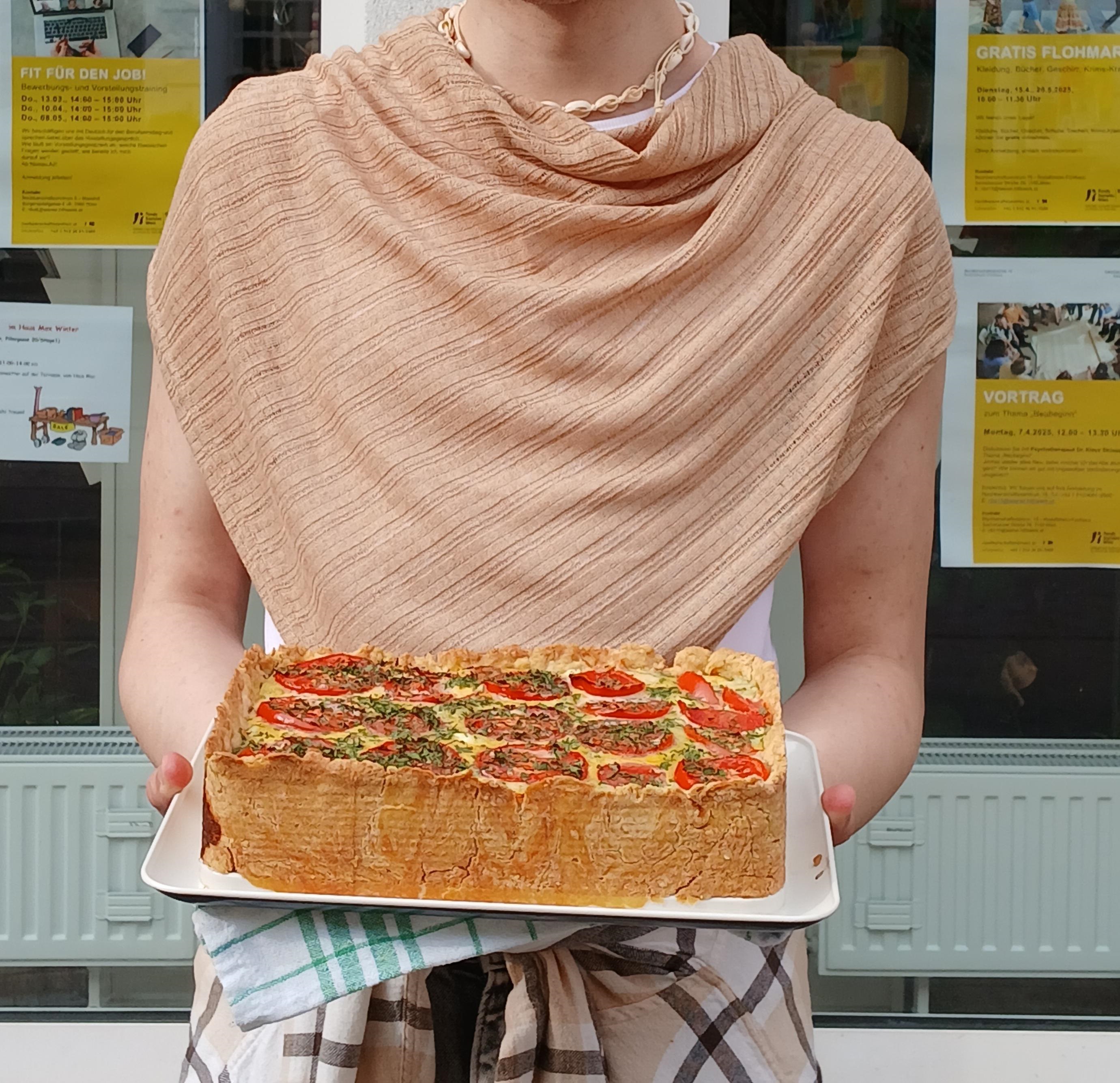 John präsentiert seine Quiche vor dem Sprachencafé.
