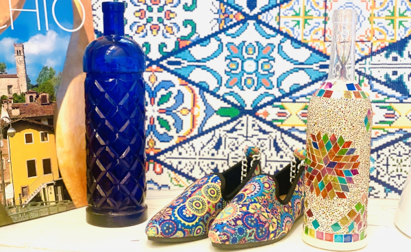 Auf einem Tisch werden farbige Schuhe und Vasen angeboten,