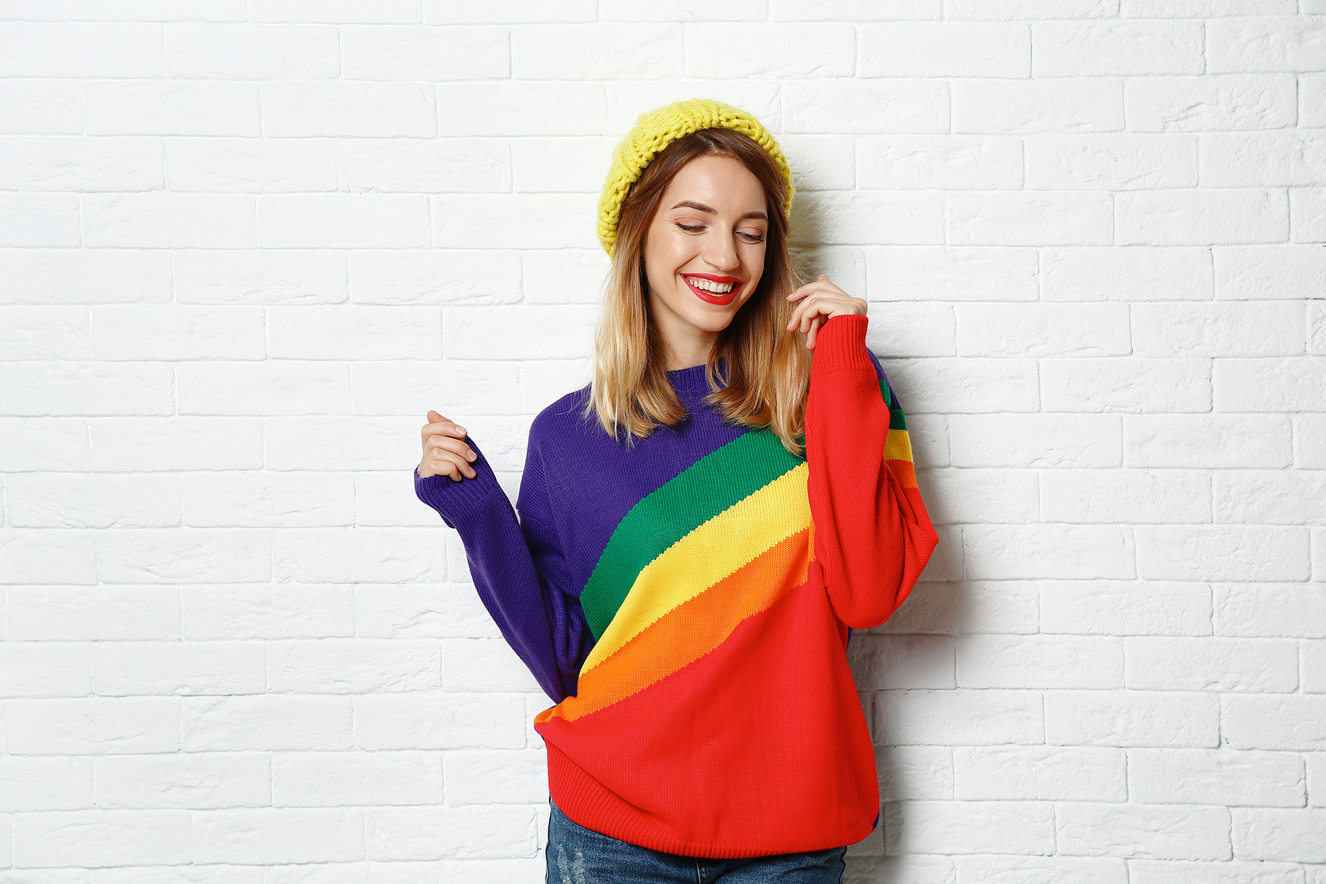eine lachende junge Frau mit einen Regenbogen Shirt.  