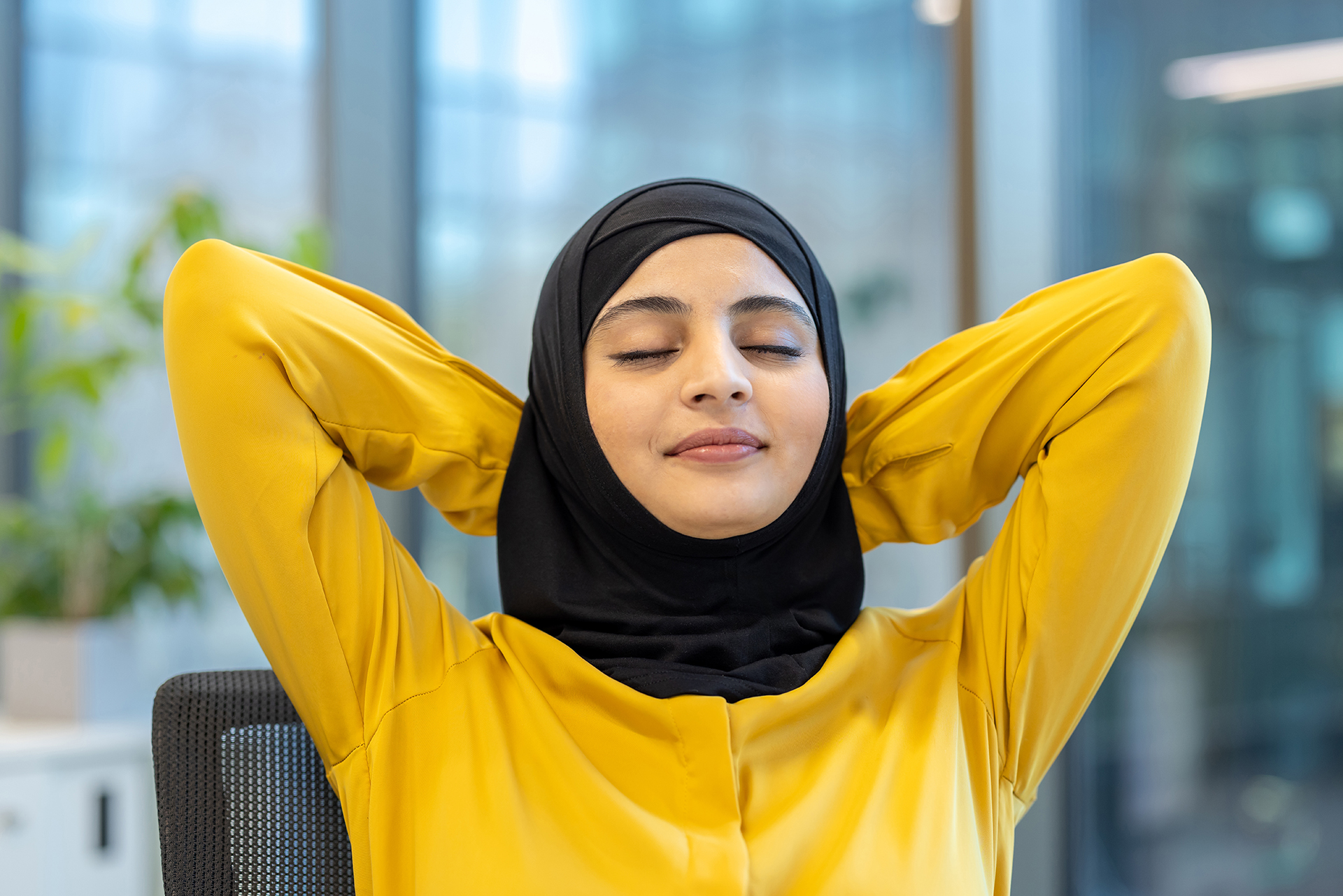 Eine Frau massiert sich entspannt den Nacken.