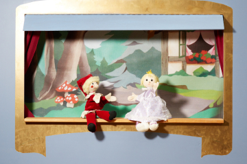 Kasperl und Prinzessin sitzen vor dem Kasperlhaus am Bühnenrand und plaudern.