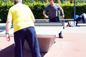 Zwei Männer spielen Tischtennis im Park