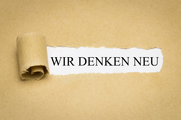 Papier mit der Aufschrift „Wir denken neu“