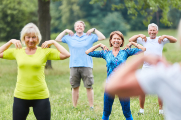 Eine Gruppe macht Sport im Grünen