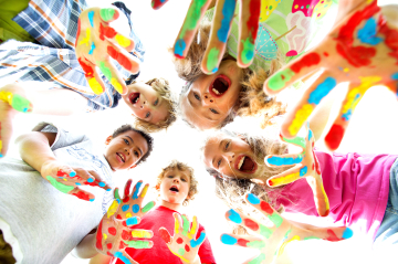 Kinder stehen im Kreis und zeigen ihre bunt bemalten Handflächen