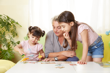 Eine erwachsene Person bastelt mit zwei Kindern