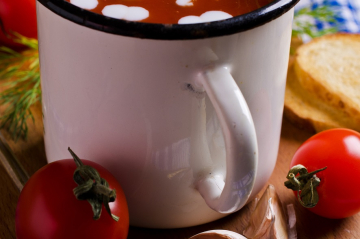 dekorierte Tomatensuppe im Häferl, daneben Gemüse